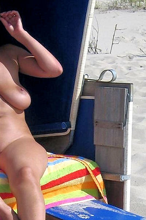 Nudist cutie takes off her clothes at public beach