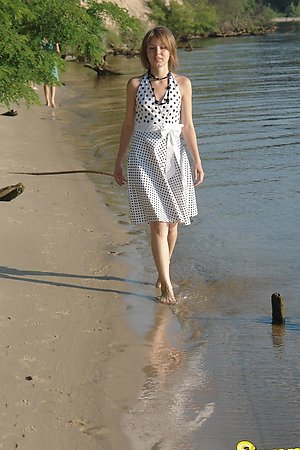Smiling young blonde undressing and having nude fun in the water